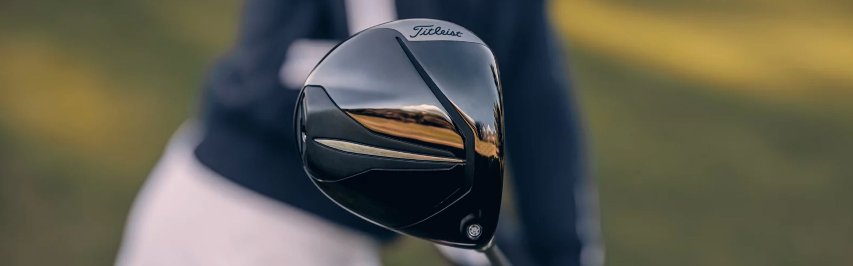 Close up of a Titleist Driver as a golfer holds it. 