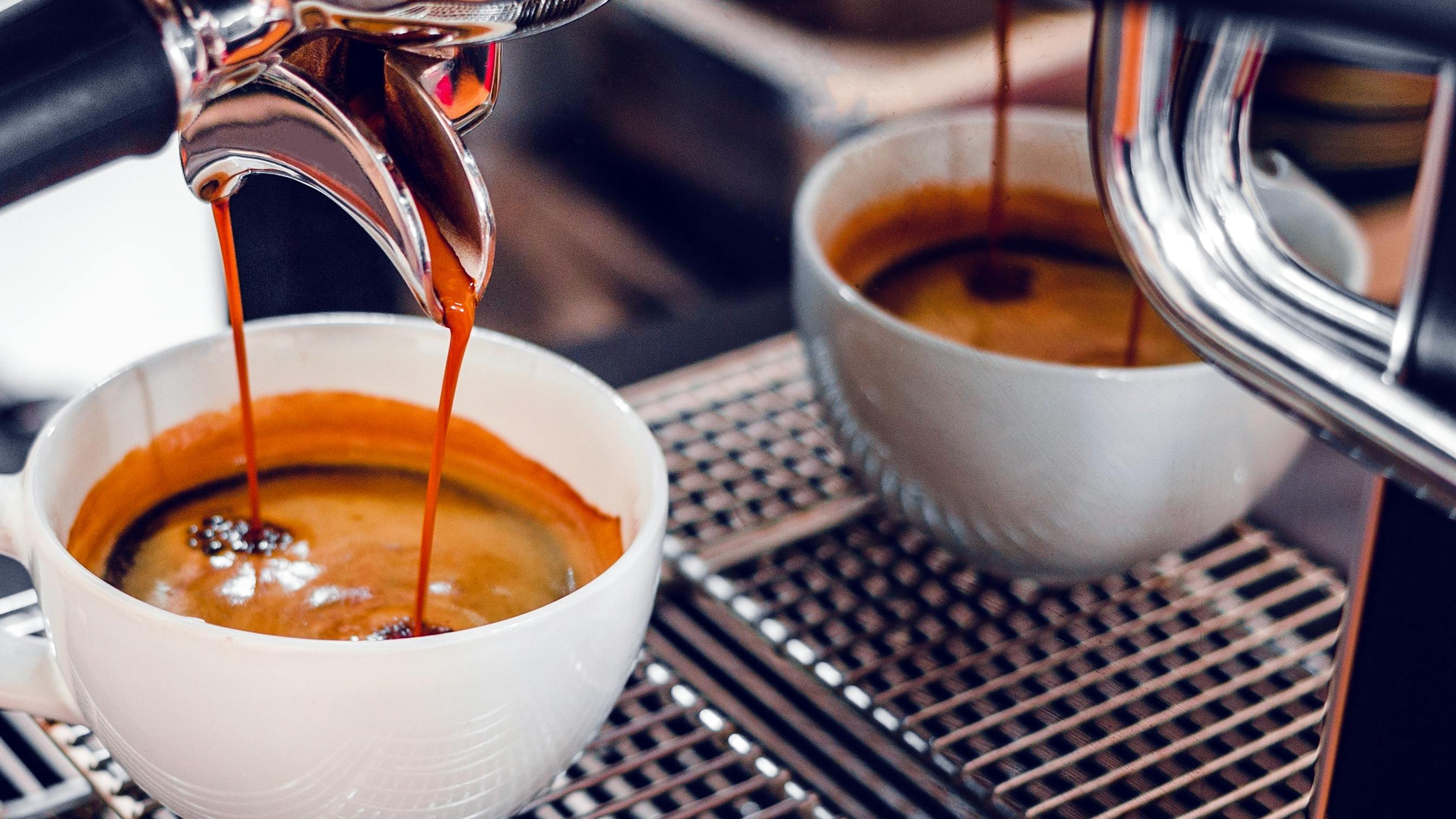 An espresso machine pouring an espresso into a cup. 