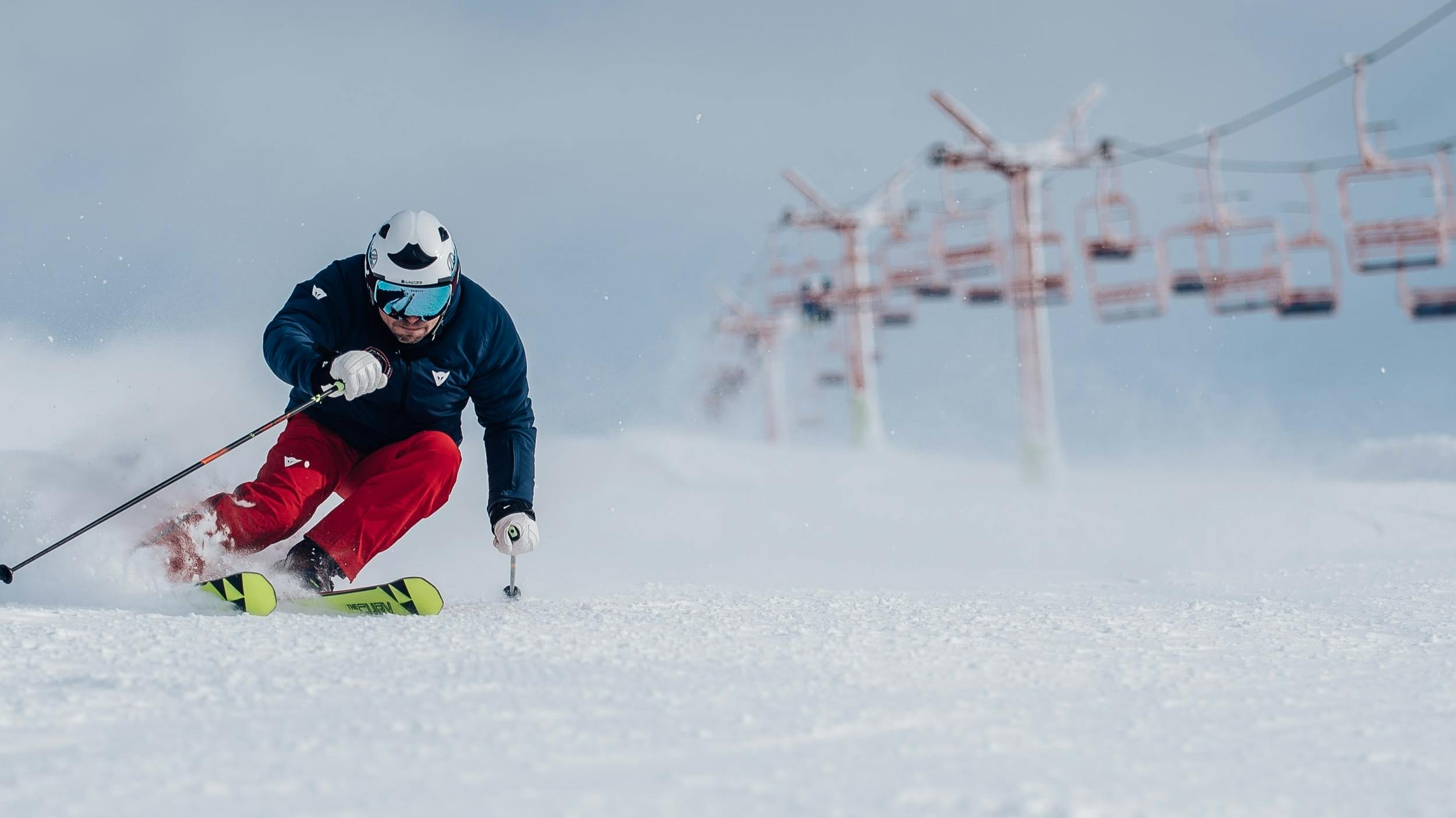 A skier carving down a groomed run. 