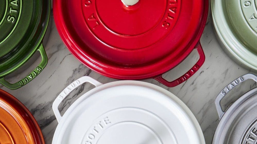 Several different colors of Staub dutch ovens as seen from above. 