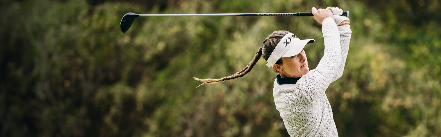A woman swinging an XXIO golf club. 
