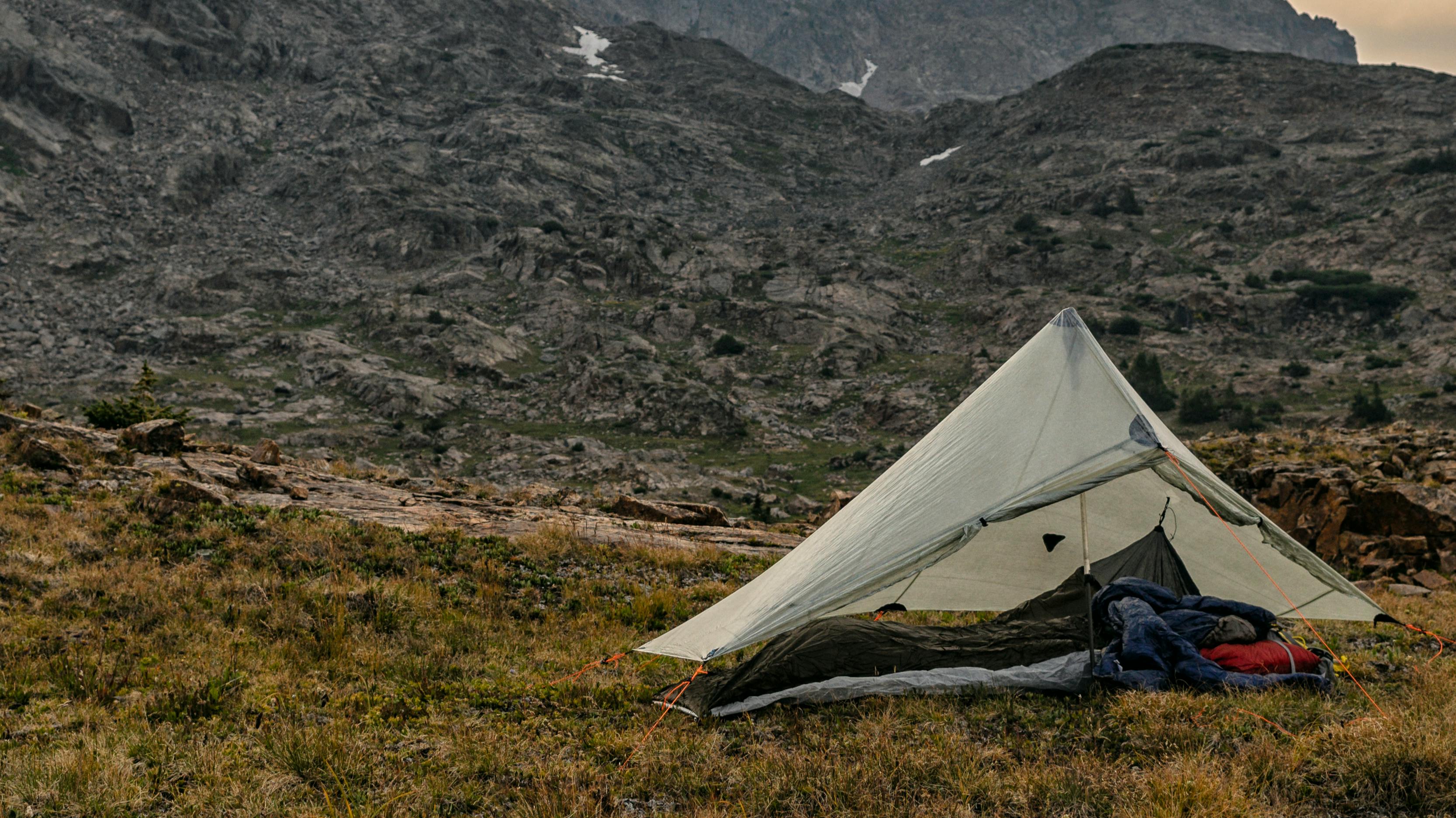 An ultralight tent set up in a rocky field.
