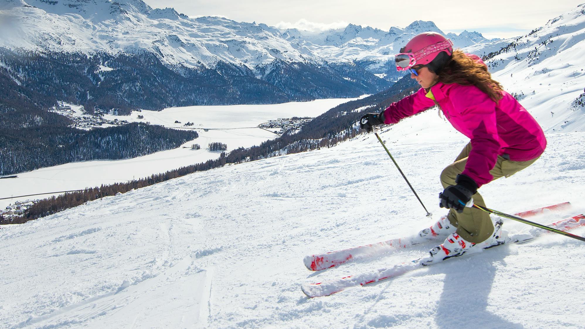 A woman skier turning down a ski slope. 