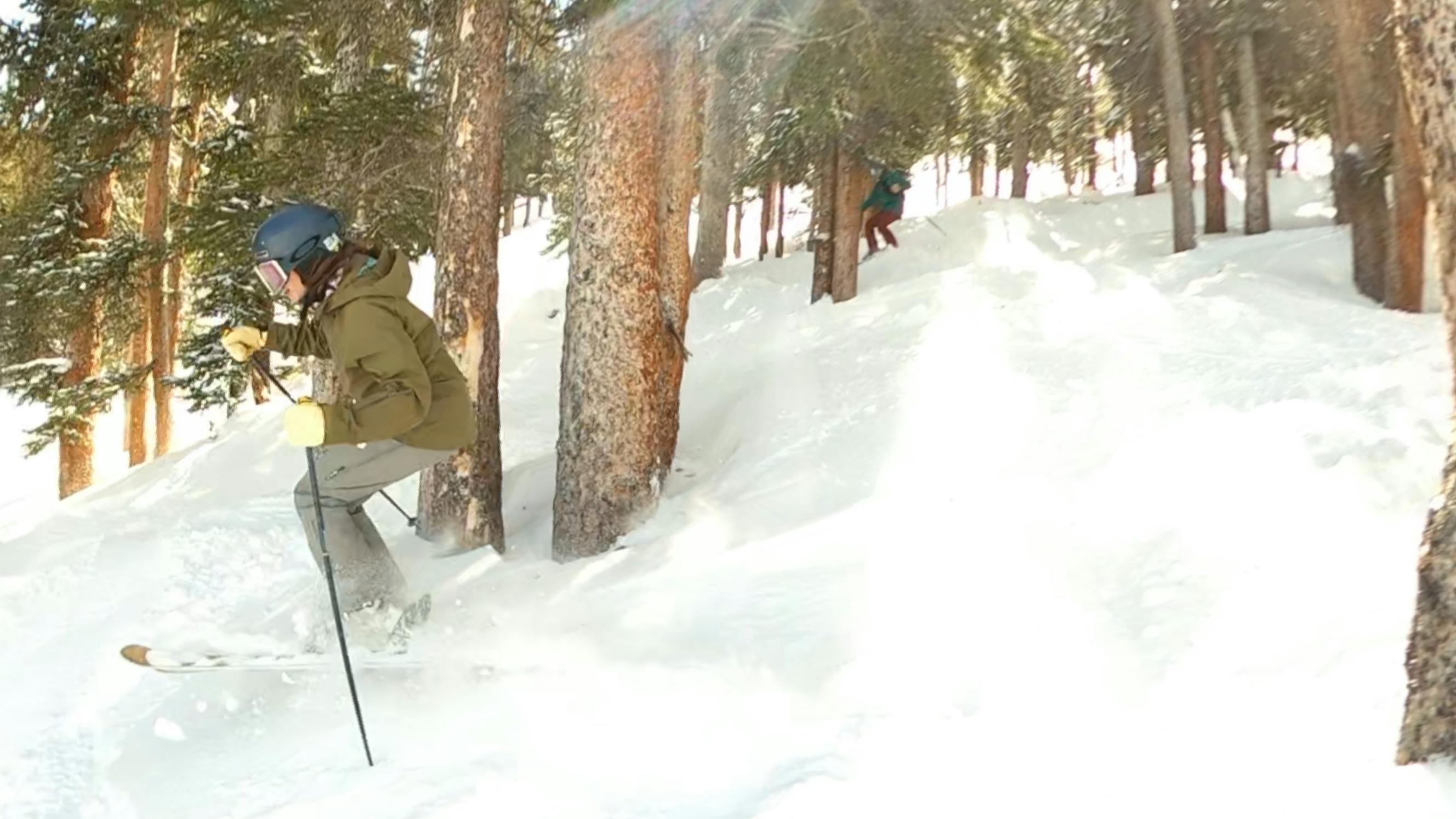 A skier going off a jump on the  Volkl Secret 102 Skis. 