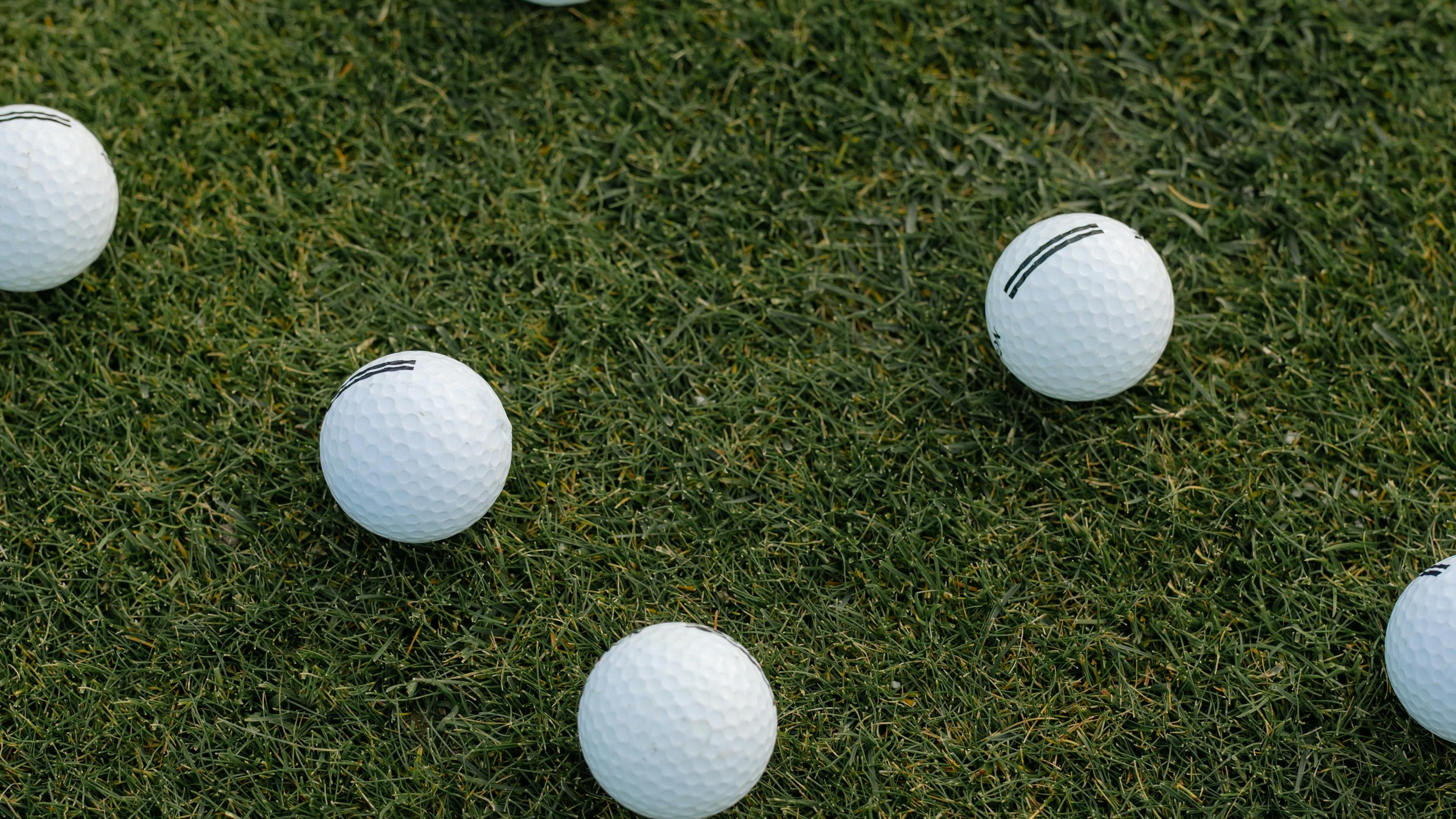 Golf Balls laying on the grass. 
