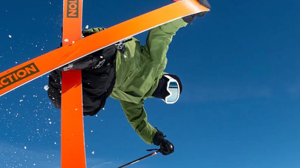 A skier does a trick on Faction skis. 
