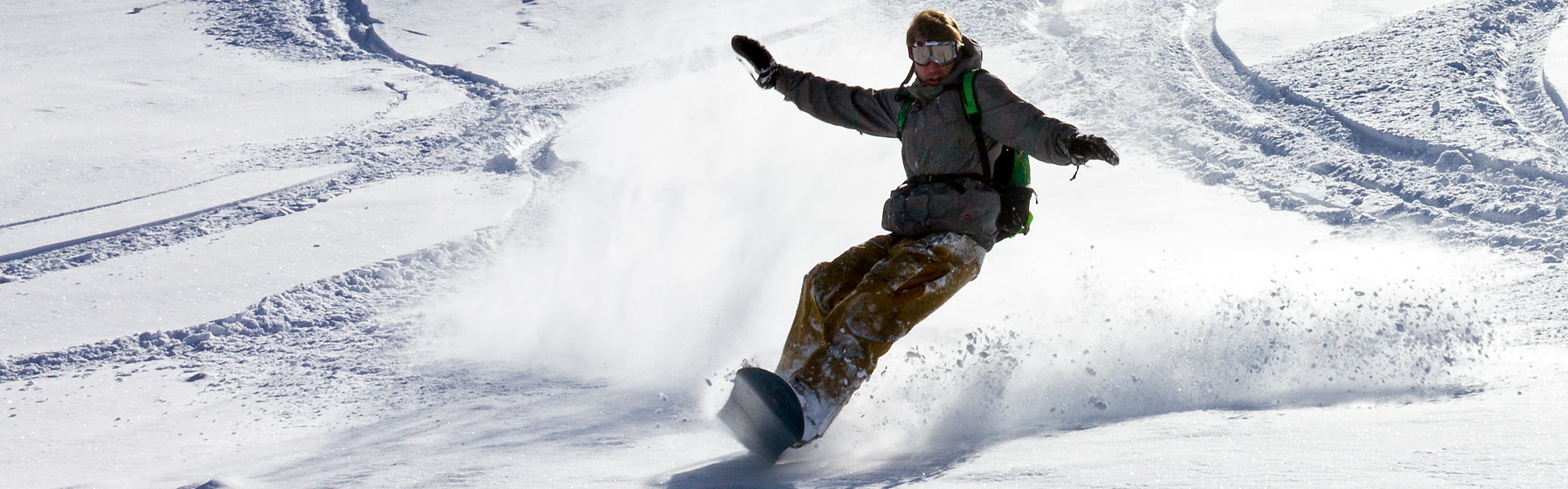 A snowboarder turning in powder. 