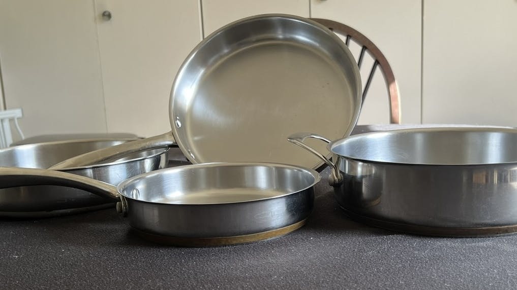 A set of different sized stainless steel pans.