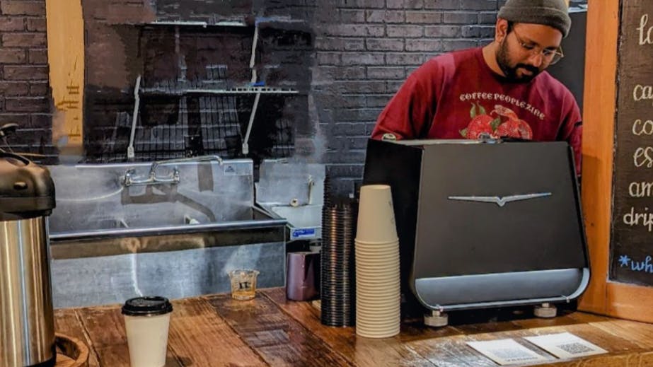 A man in a coffee shop using the Victoria Arduino Eagle One Prima Espresso Machine. 