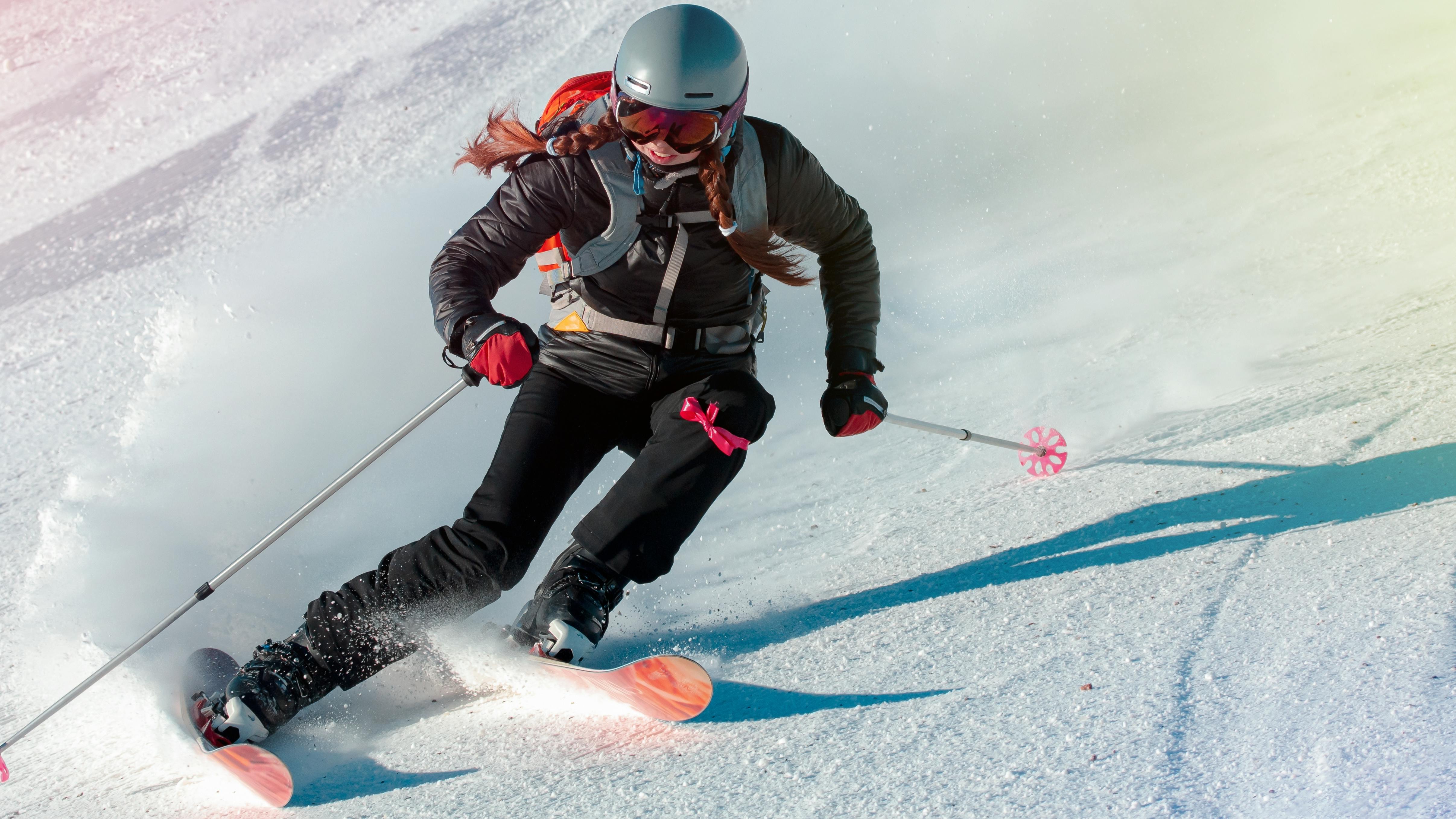 A woman skier turns down a ski slope. 