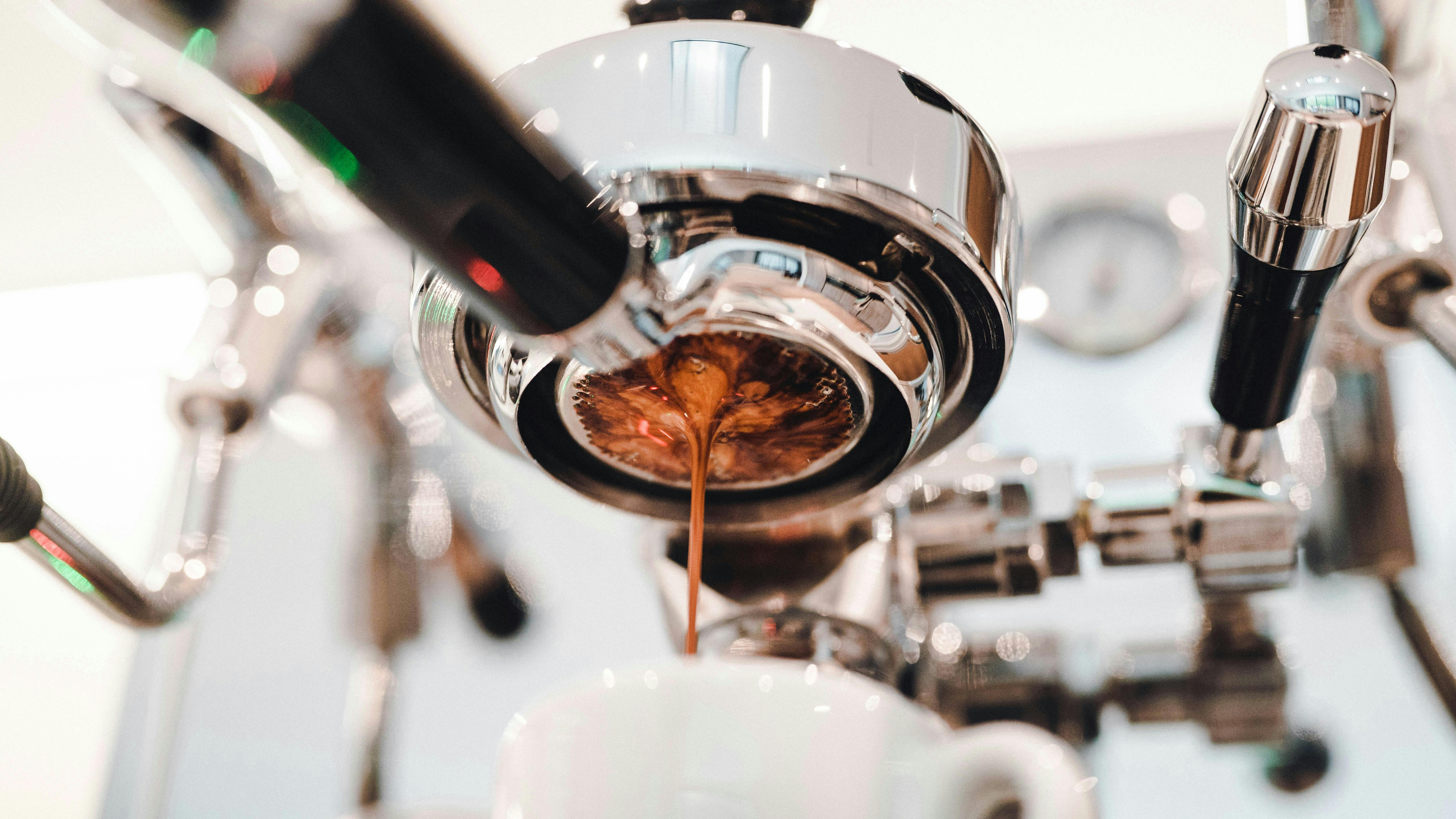 A shot of espresso pouring from a portafilter.