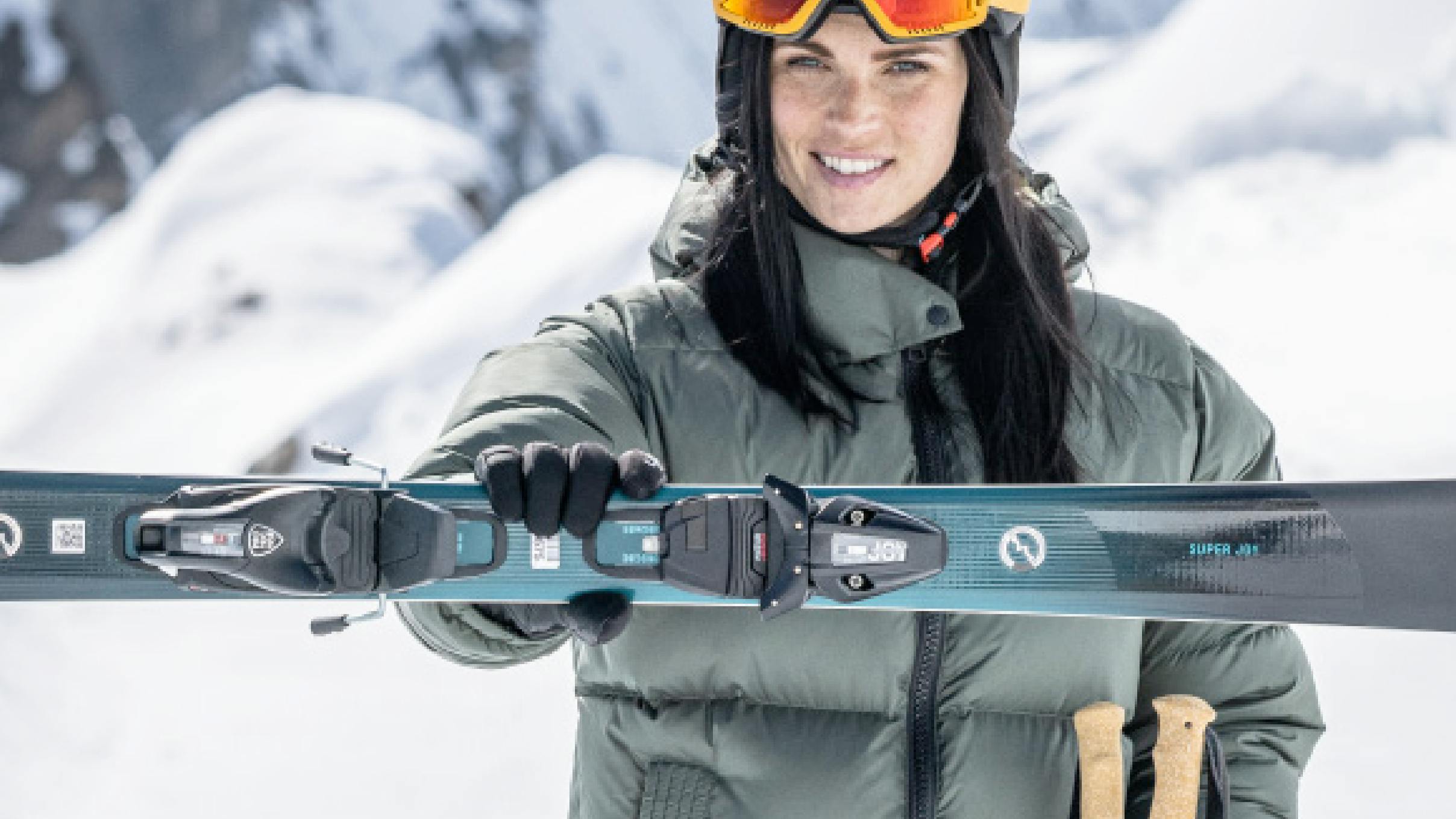 A skier holding out a ski with a Tyrolia binding mounted to it. 