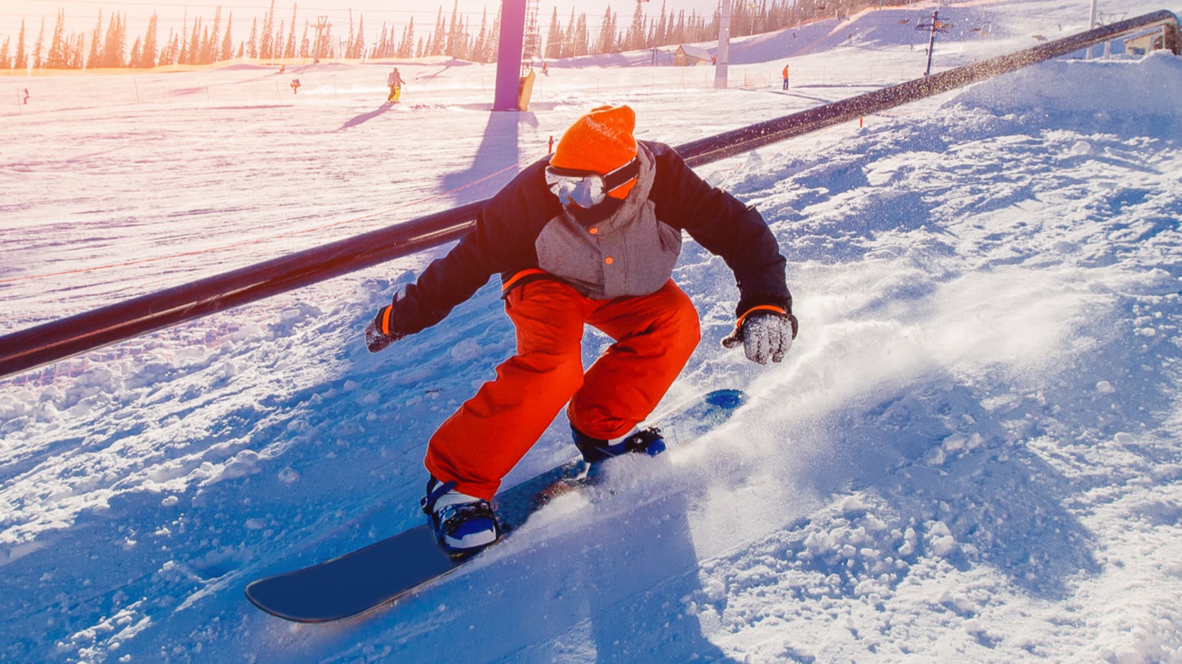 A snowboarder riding next to a rail. 