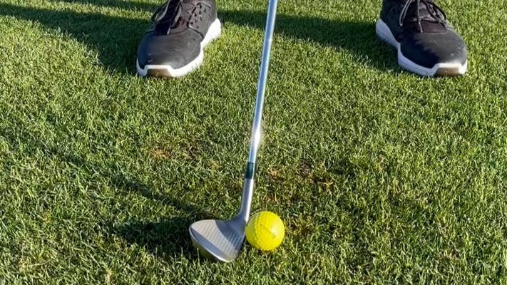 Closeup of the Mizuno S23 wedge about to hit a golf ball