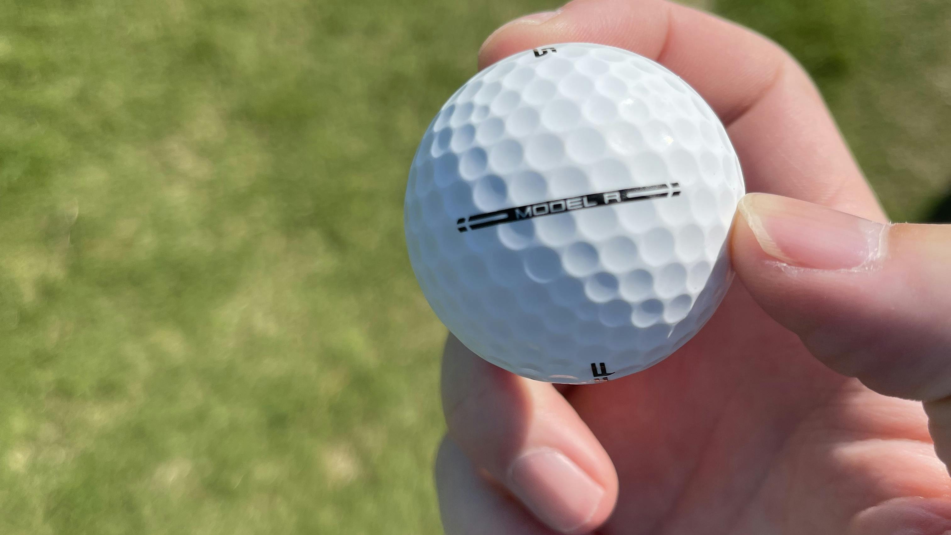 White golf ball in hand