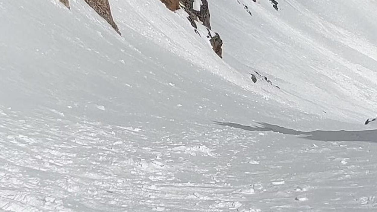 A skier standing at the top of a ski line. 