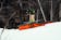 Skier sliding an orange and black down-flat-down rail.