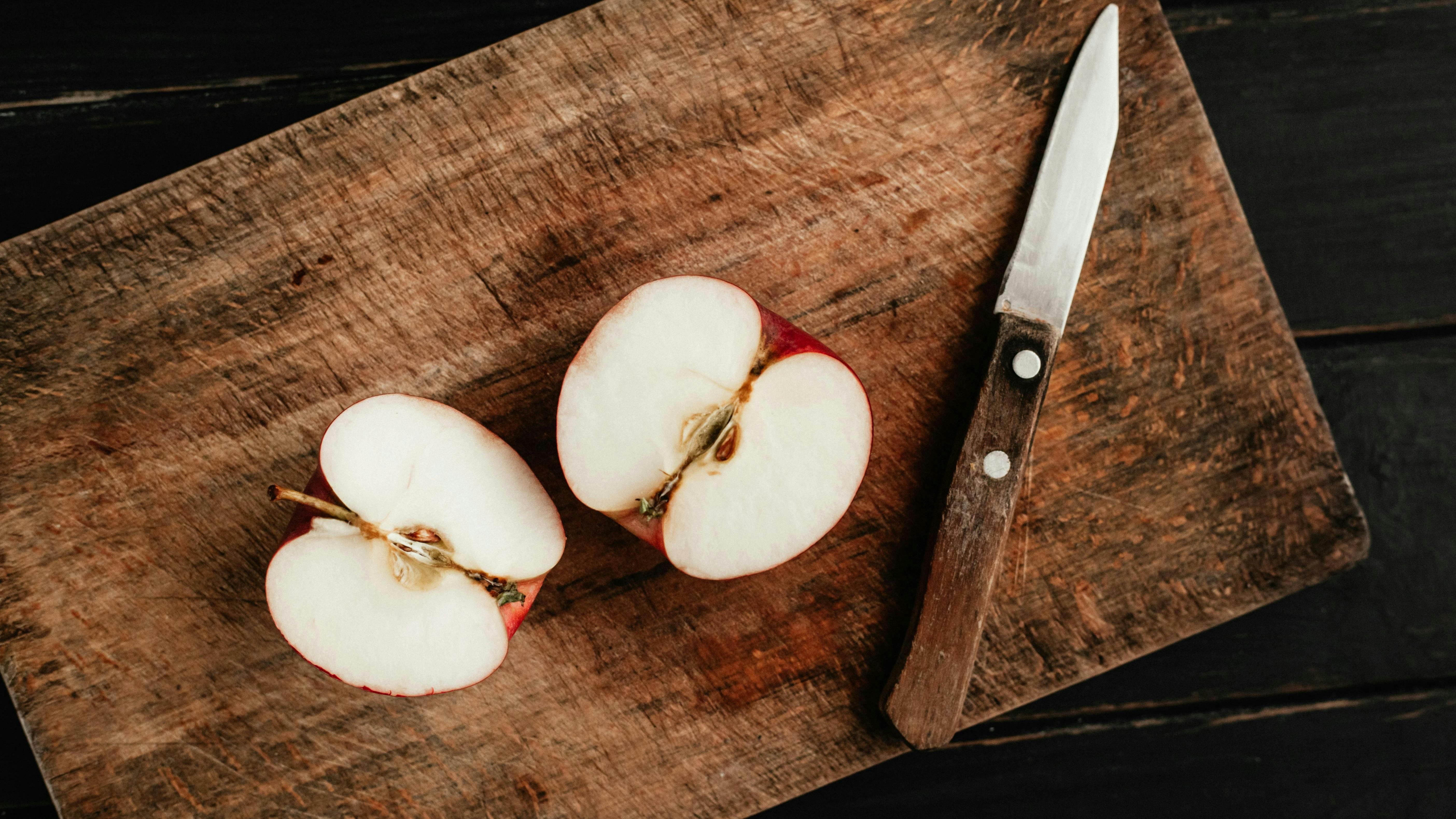 A paring knife and a small apple.