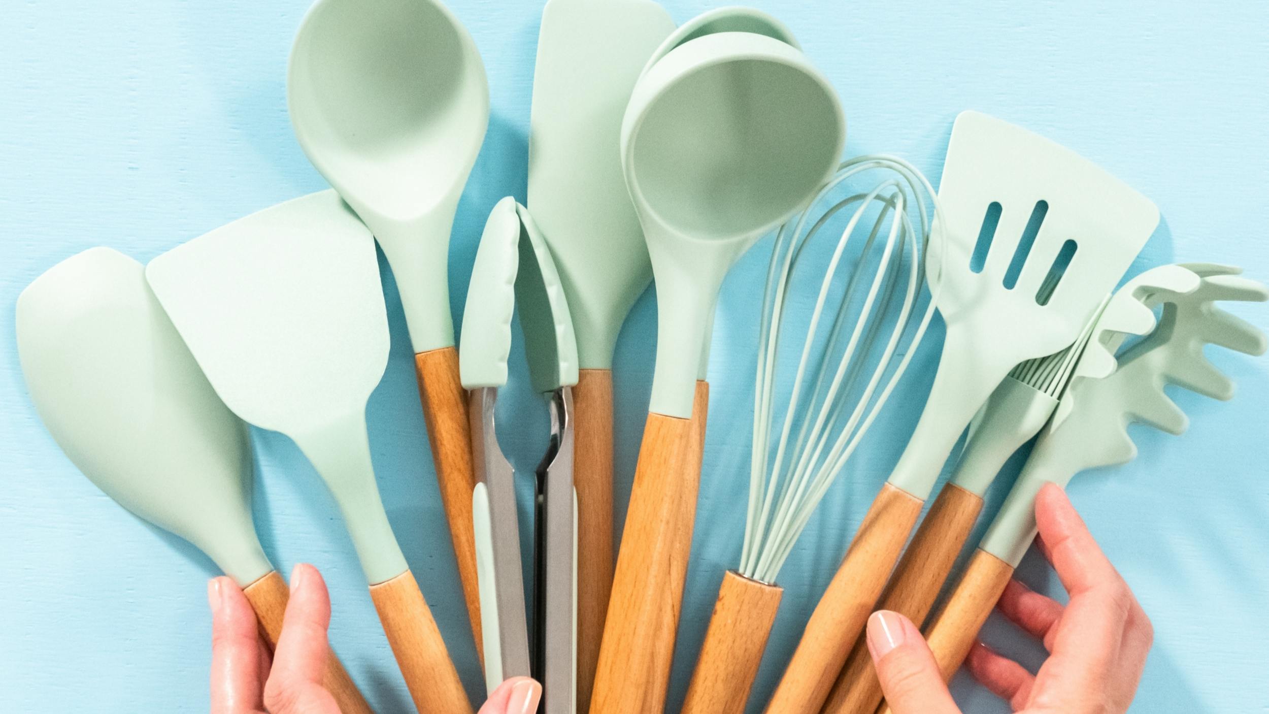 Several silicone utensils being held together with some hands. 