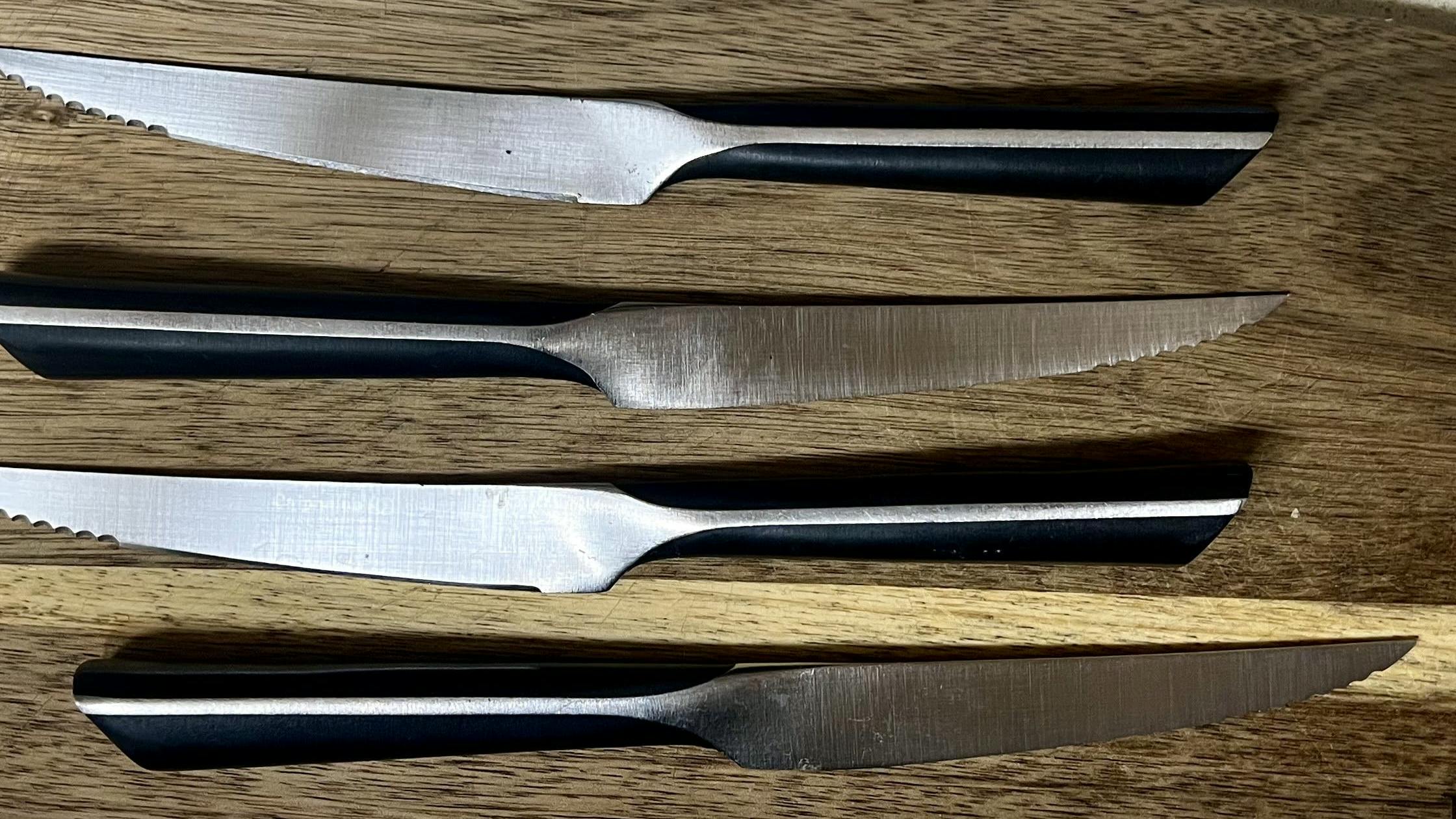 A set of four steak knives with partially serrated blades.